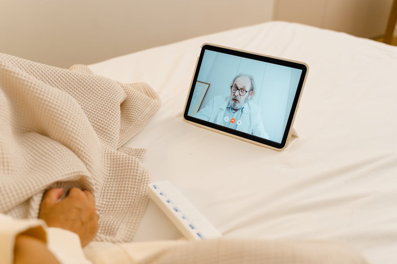 Mastering the First Impression: Your intriguing post title goes here Patient in bed having a virtual consultation with a doctor via tablet.